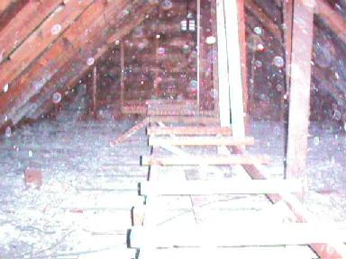 view of 
	dusty attic through frosted lens, with walkway framing visible