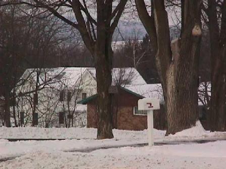 The Blue Mounds, visible through bare winter branches, rise behind the house.