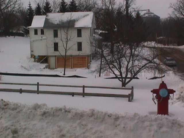 view of house from east with full snowcover and plowed banks along the streets