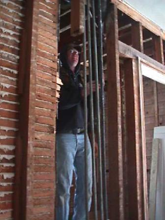 Carpenter Kirk inspects an open wall