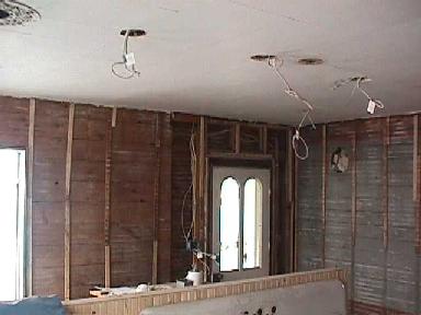 electric cables hang from five holes in the kitchen ceiling where light fixtures will be