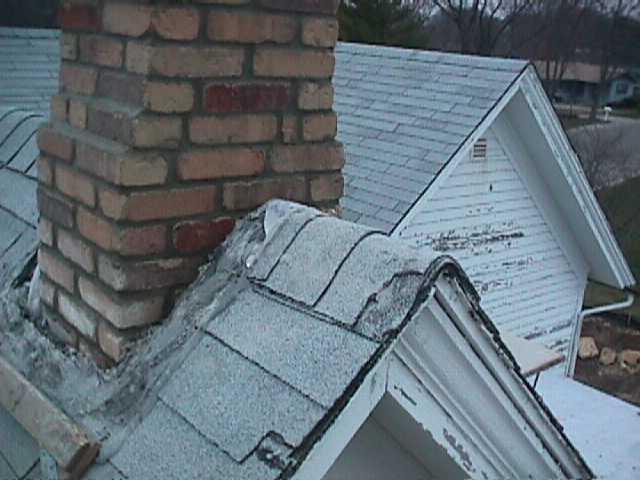 view past brick chimney and steep roof gable to east wing of house and ground 4 stories below.