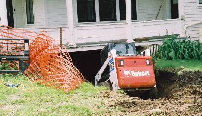 The movers' Bobcat tunnels beneath the house.