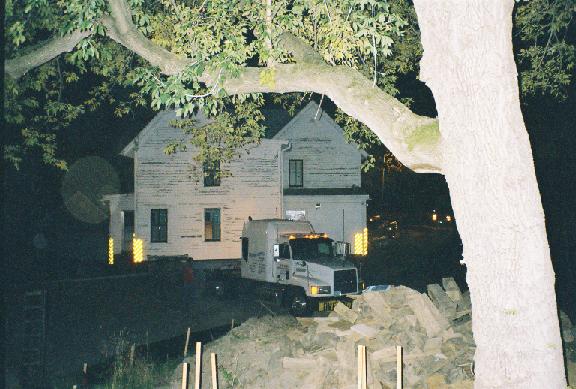 cab turning into driveway pulling house; box elder in foreground