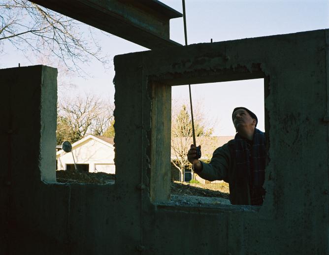 Brian, seen through the window opening in the silhouettes of the foundation walls, 
uses a tape measure to check the alignment of the basement to the house.
