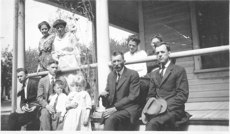 The Gesme family seated and standing on the front porch.